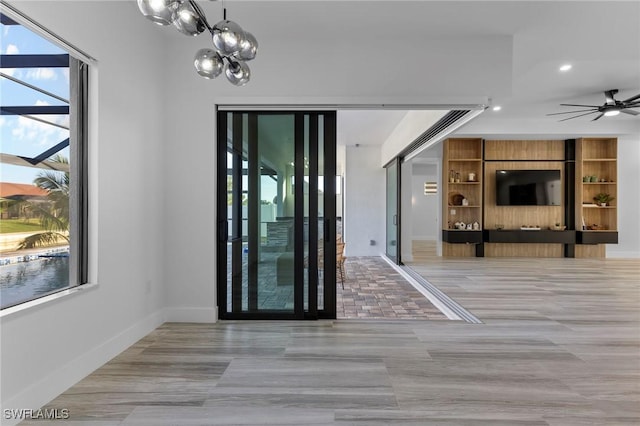 interior space featuring ceiling fan with notable chandelier and light tile patterned floors