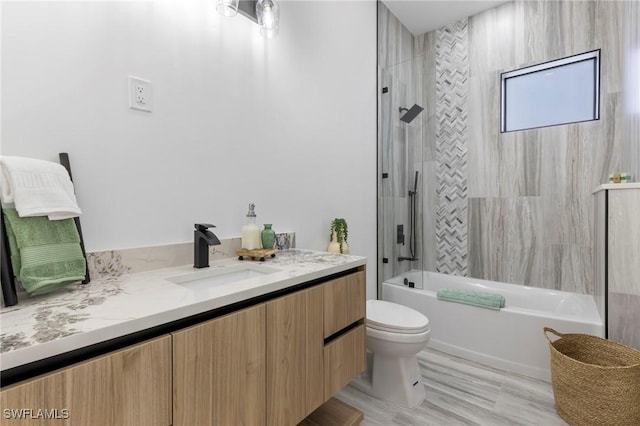 full bathroom with tiled shower / bath combo, vanity, and toilet