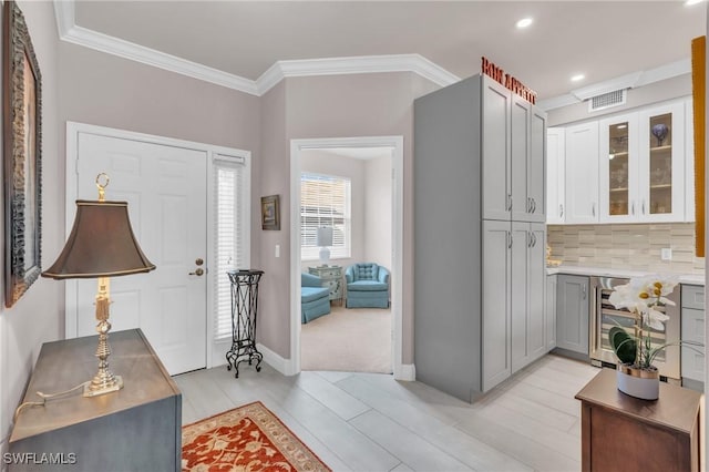 foyer entrance featuring wine cooler and crown molding