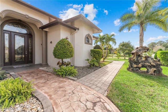 property entrance featuring a lawn