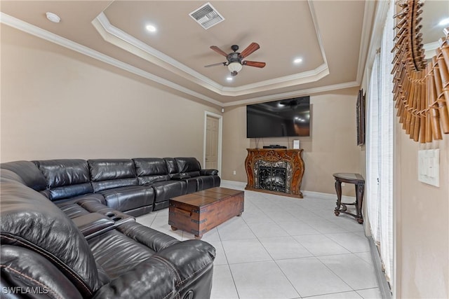 tiled living room with ceiling fan, crown molding, and a raised ceiling