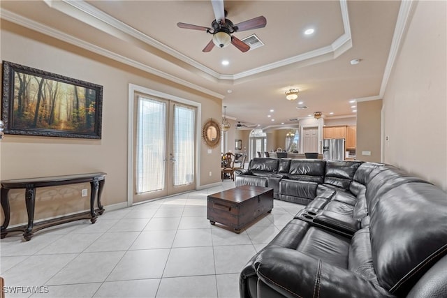 living room featuring a tray ceiling, french doors, ornamental molding, ceiling fan, and light tile patterned floors