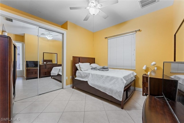 bedroom featuring ceiling fan, light tile patterned floors, and a closet