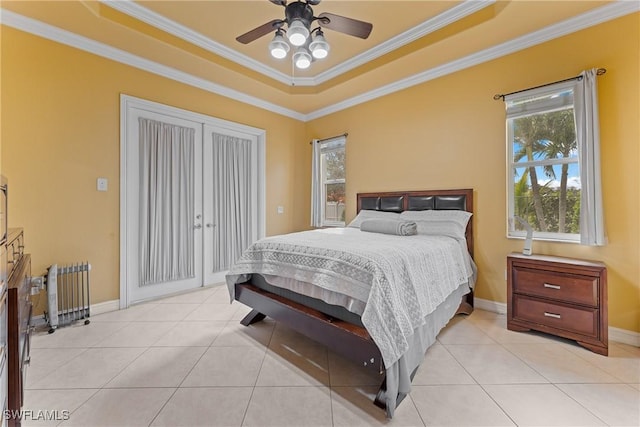 tiled bedroom featuring radiator, ceiling fan, ornamental molding, and a raised ceiling