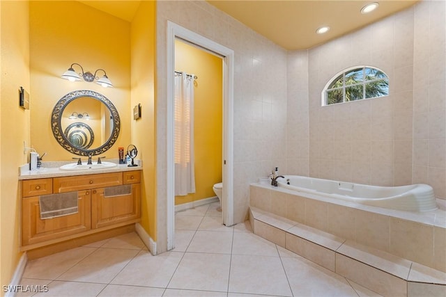 bathroom featuring toilet, vanity, tile patterned floors, and a relaxing tiled tub