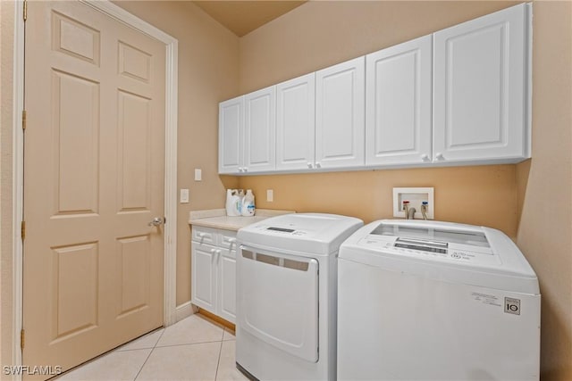 washroom featuring cabinets, separate washer and dryer, and light tile patterned floors