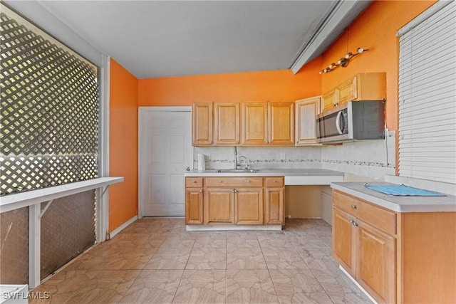 kitchen with tasteful backsplash, light brown cabinetry, and sink