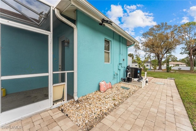 view of side of property featuring a patio area and a lawn