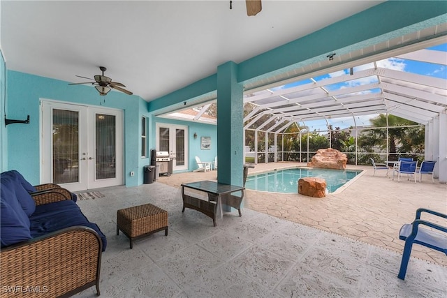 view of swimming pool with glass enclosure, a patio area, french doors, ceiling fan, and grilling area