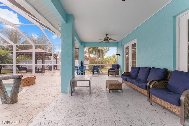 view of patio / terrace with ceiling fan, an outdoor living space, and glass enclosure