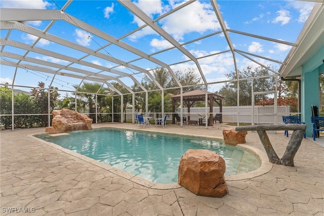 view of swimming pool with pool water feature, a gazebo, a patio area, and glass enclosure