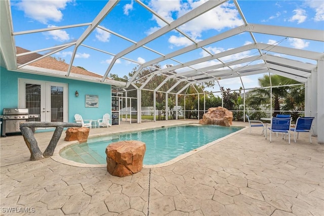 view of pool featuring a patio, glass enclosure, and area for grilling