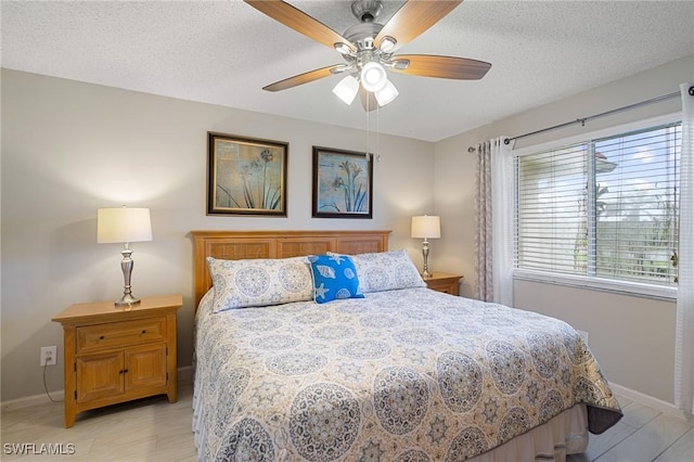 bedroom featuring a textured ceiling, light hardwood / wood-style flooring, and ceiling fan