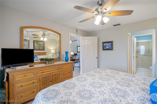 bedroom with ceiling fan, ensuite bathroom, and a textured ceiling