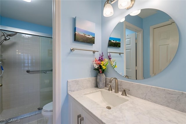 bathroom with toilet, a shower with door, and vanity