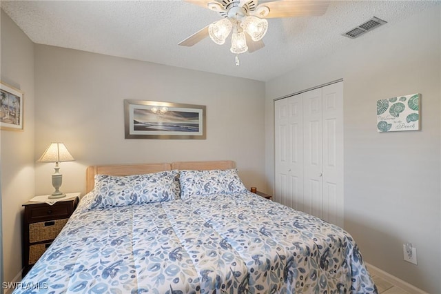 bedroom with a textured ceiling, a closet, and ceiling fan