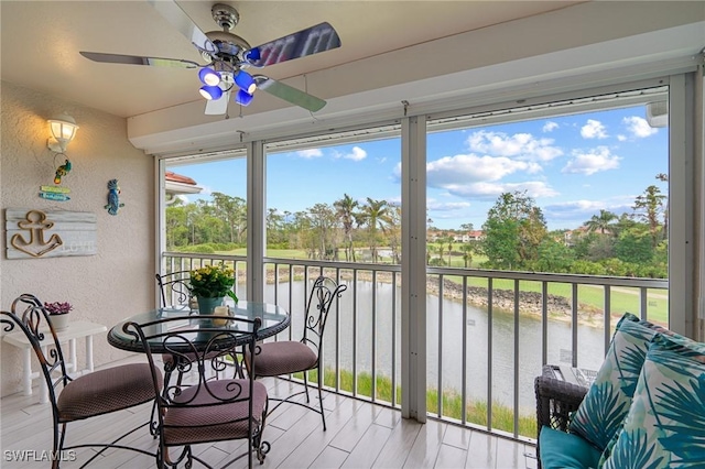 sunroom featuring a water view