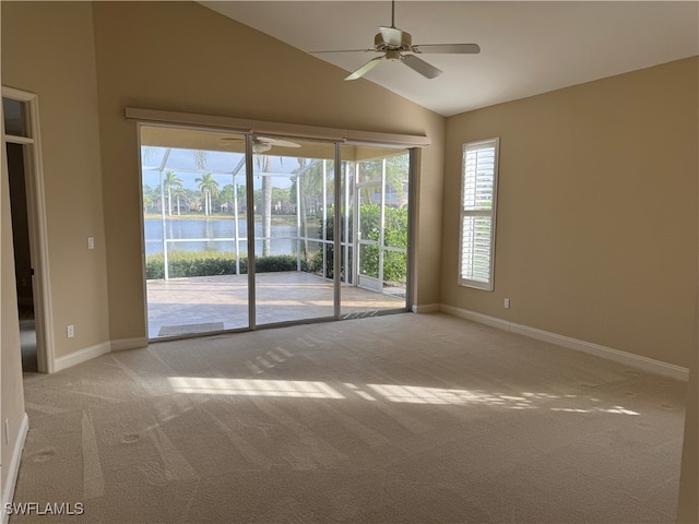 unfurnished room featuring a water view, light carpet, lofted ceiling, and ceiling fan