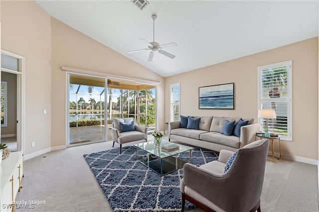 living room featuring high vaulted ceiling, light colored carpet, ceiling fan, and a water view