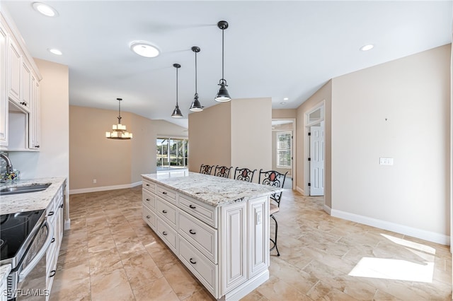 kitchen with white cabinetry, sink, a kitchen breakfast bar, a center island, and electric range