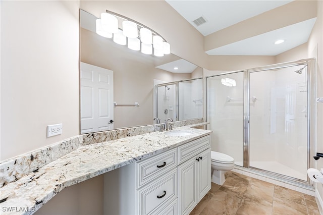 bathroom featuring vanity, a shower with door, and toilet