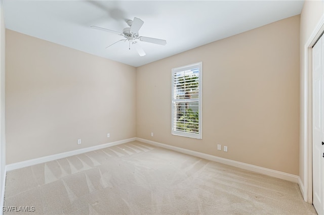 spare room with light carpet and ceiling fan