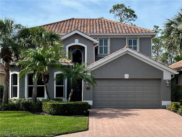 mediterranean / spanish-style house with a front yard and a garage