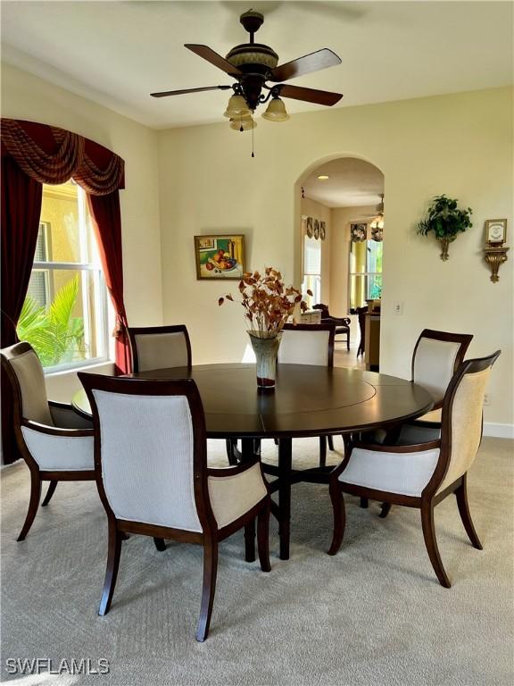 carpeted dining room featuring ceiling fan