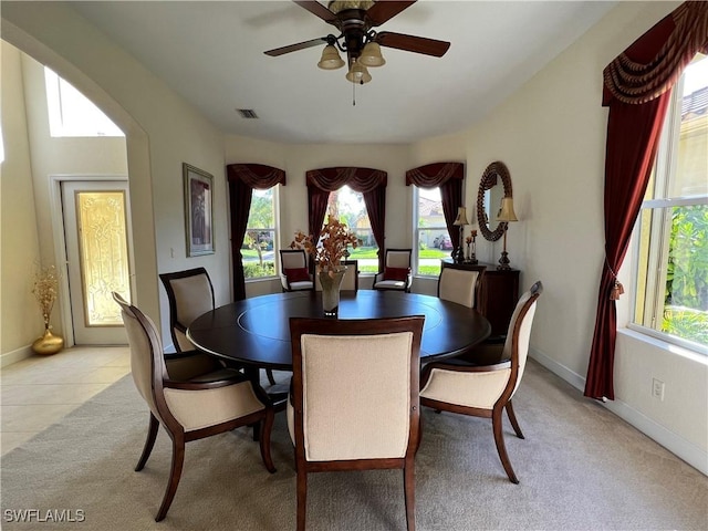 carpeted dining room featuring ceiling fan and plenty of natural light