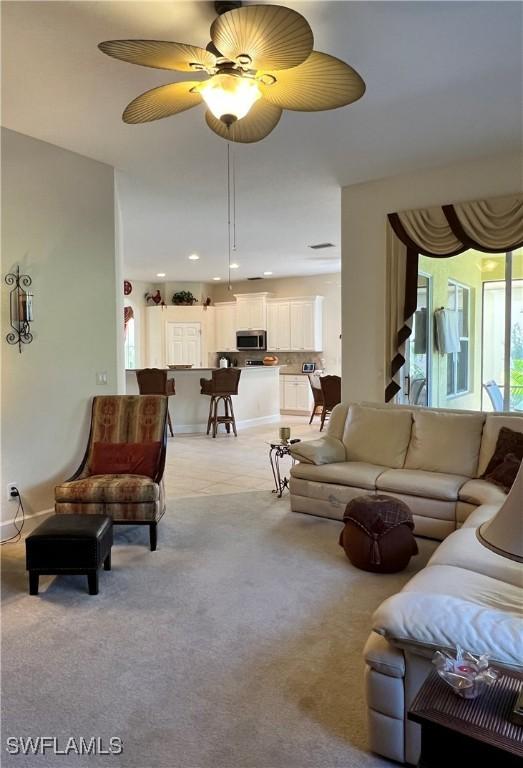 living room with ceiling fan and light colored carpet