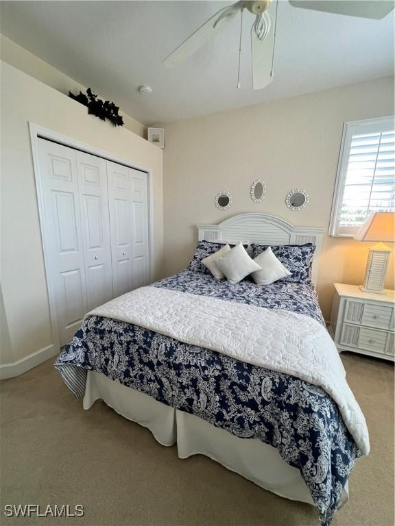 bedroom with ceiling fan, carpet, and a closet