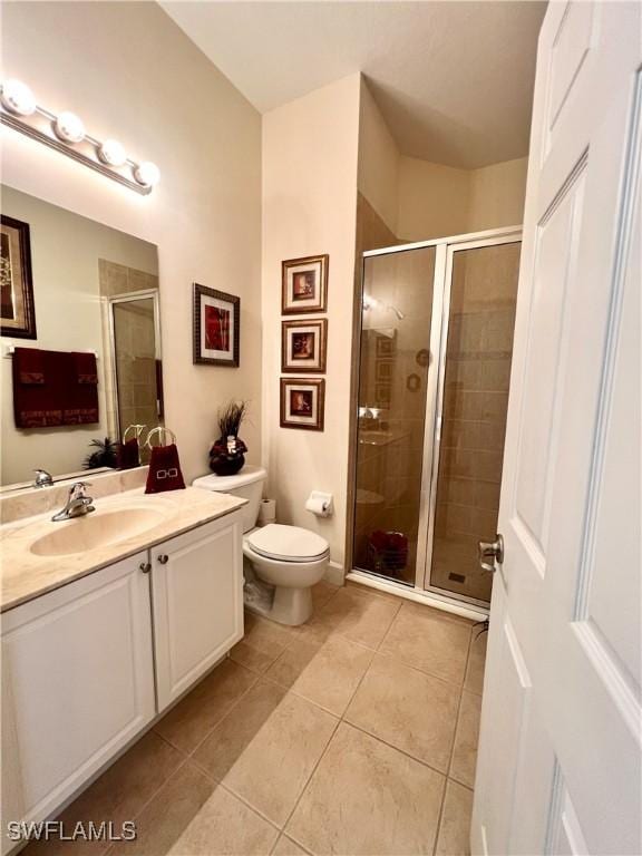 bathroom featuring vanity, toilet, tile patterned floors, and walk in shower