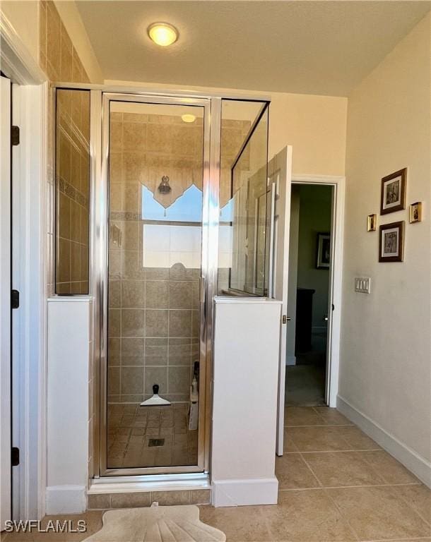 bathroom featuring tile patterned floors and a shower with door