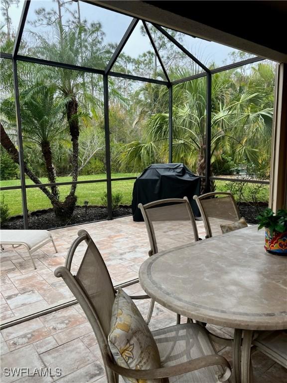 view of patio / terrace featuring glass enclosure and area for grilling