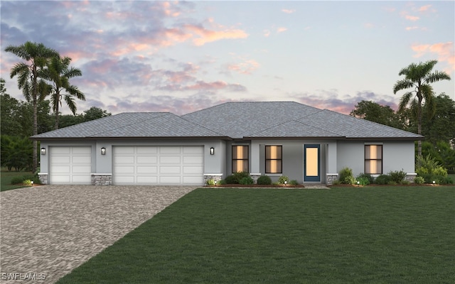 prairie-style house featuring a garage and a lawn