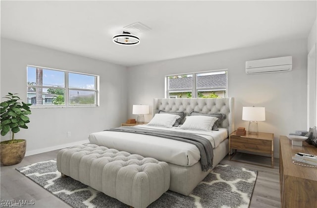 bedroom with light wood-type flooring and a wall mounted air conditioner