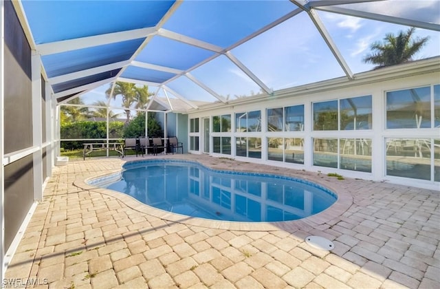 view of pool featuring glass enclosure and a patio