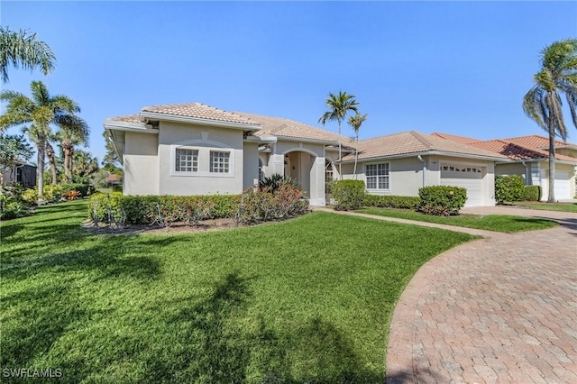 view of front of house with a front lawn, decorative driveway, a tiled roof, and an attached garage