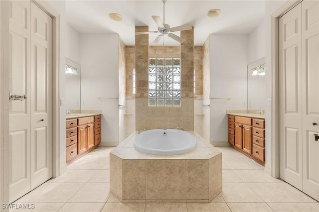 bathroom featuring two vanities, a garden tub, and tile patterned floors