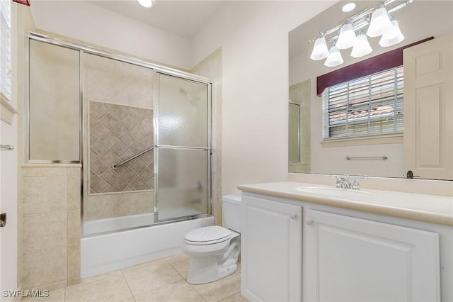 bathroom with toilet, shower / bath combination with glass door, tile patterned flooring, and vanity