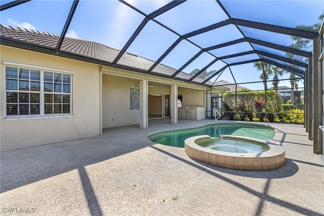 view of swimming pool featuring a pool with connected hot tub, a patio area, and a lanai