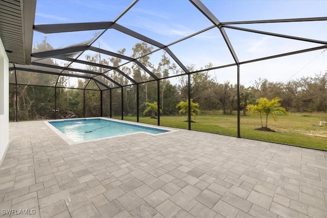 view of pool featuring a lawn, a patio, and glass enclosure