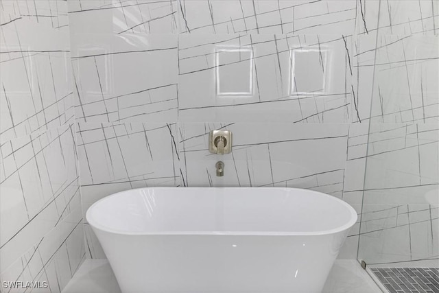 bathroom with tile walls and a bathtub