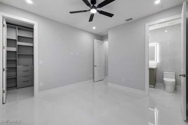 bedroom featuring ceiling fan, ensuite bath, a closet, and a spacious closet