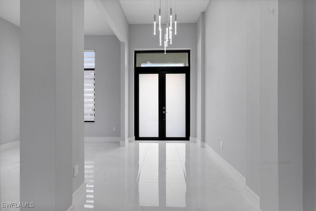 entrance foyer with a notable chandelier and french doors