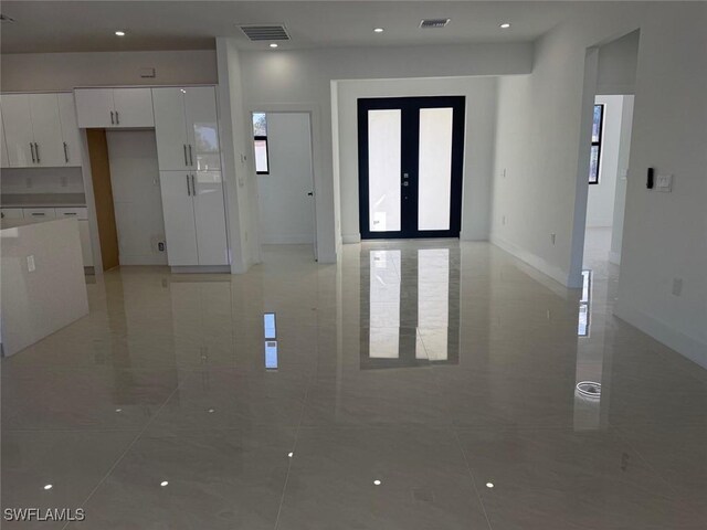 interior space with white cabinets and french doors