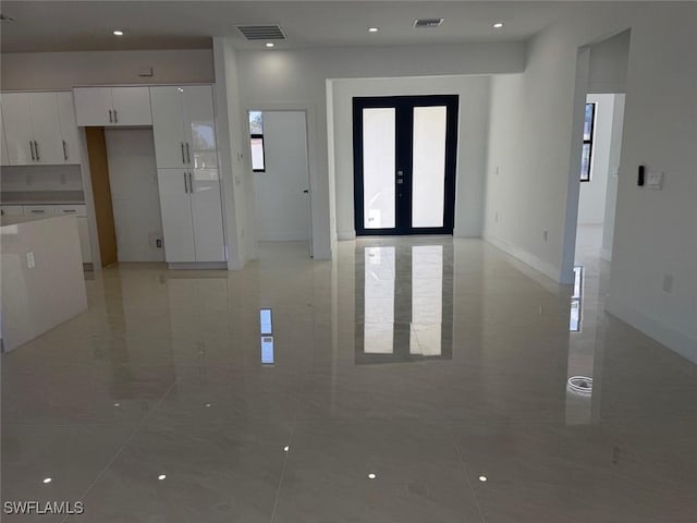 spare room featuring marble finish floor, french doors, and visible vents