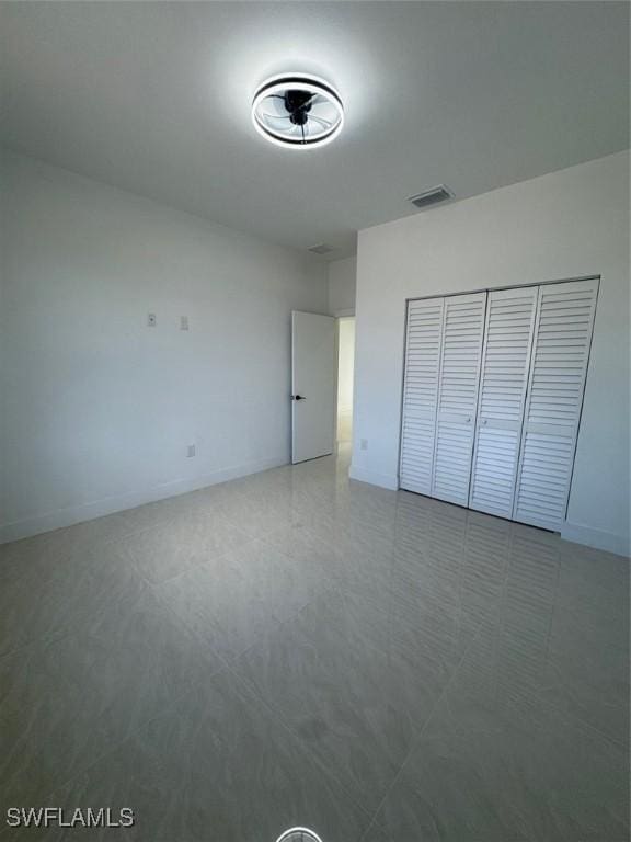 unfurnished bedroom with a closet, visible vents, and baseboards