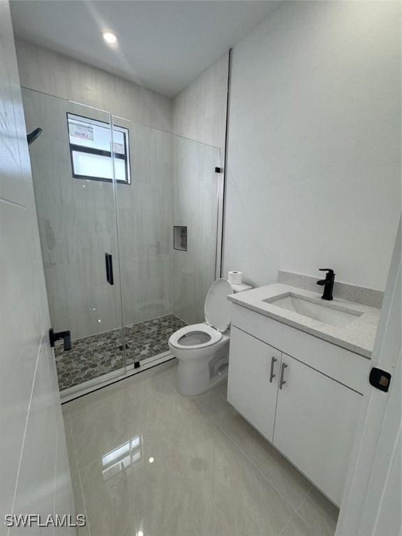 bathroom featuring a shower with shower door, toilet, and vanity