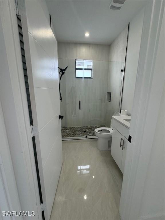 bathroom with toilet, vanity, and a tile shower